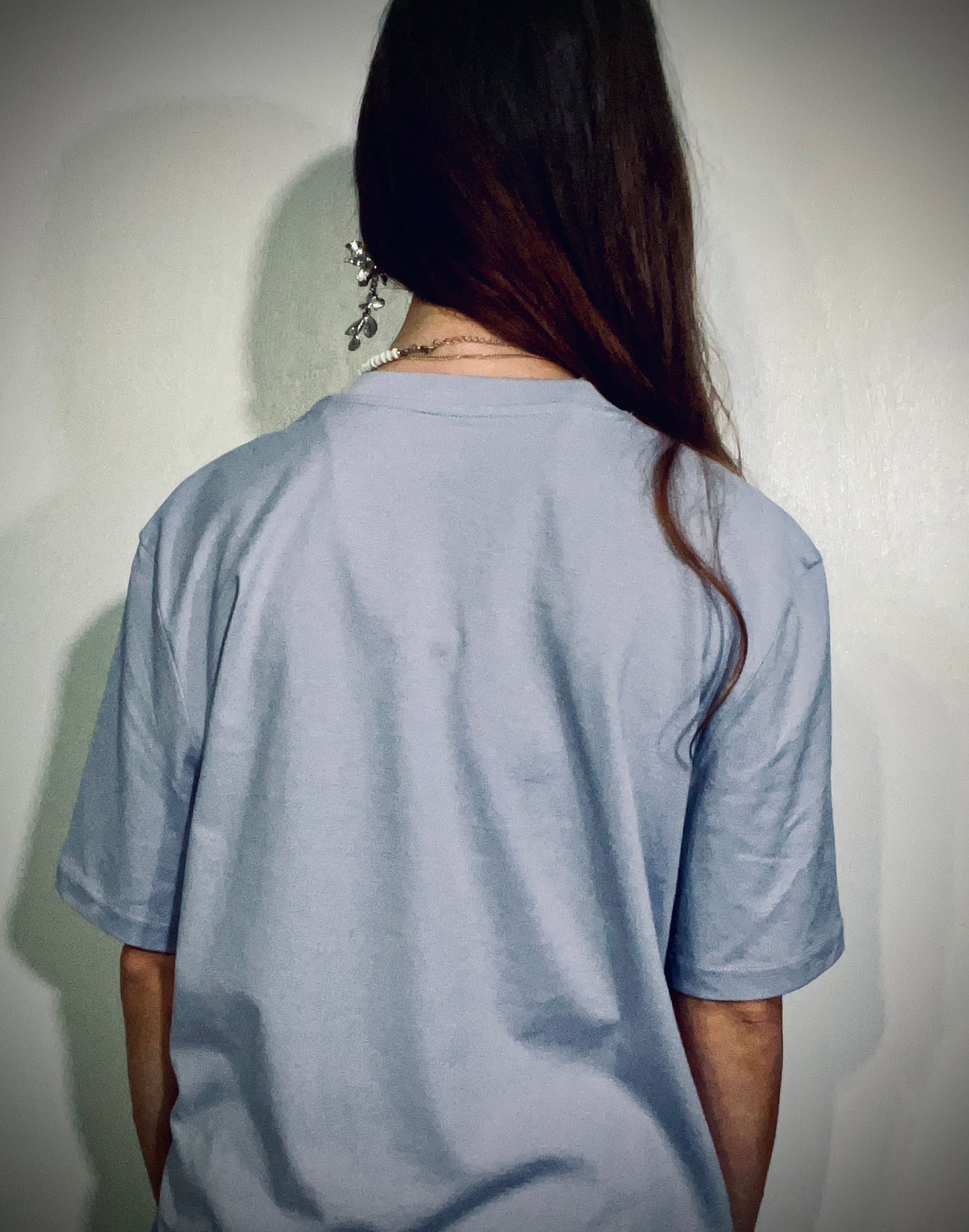 We Need Powder!! Coming!! ~ 100% organic cotton Tee ~ lilac ~ relaxed fit ~ gender neutral ~ silver & black embroidered text in orange and red embroidered speech bubbles ~ back view