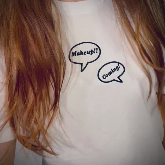 video: Makeup!! Coming!! ~ 100% organic cotton Tee ~ relaxed fit ~ gender neutral ~ white ~ embroided black text in speech bubbles design 