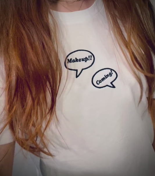 video: Makeup!! Coming!! ~ 100% organic cotton Tee ~ relaxed fit ~ gender neutral ~ white ~ embroided black text in speech bubbles design 
